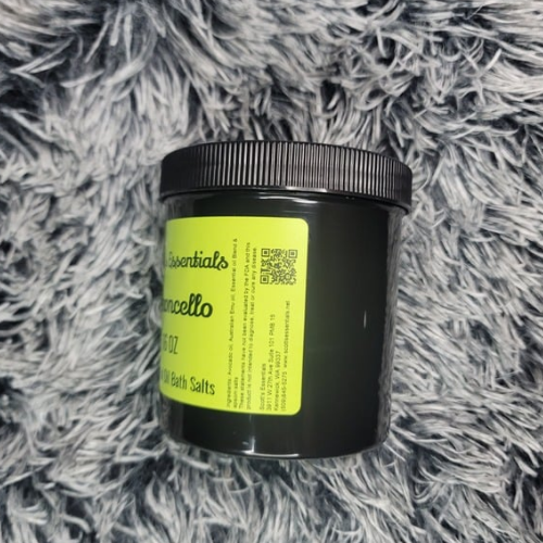 Black jar with a yellow label on a gray textured surface