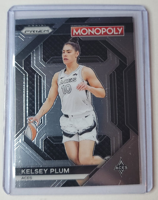 Basketball trading card of Kelsey Plum with Monopoly branding on a reflective surface.