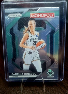 Monopoly trading card featuring a basketball player Sabrina Ionescu in a protective case.