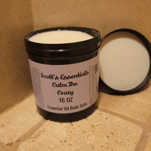 Bottle of Scott's Essentials Calm The Crazy Essential Oil Bath Salts on a tiled surface ith lid off.