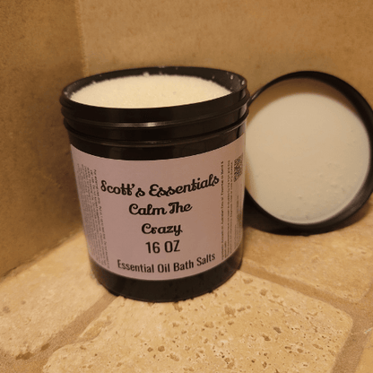 Bottle of Scott's Essentials Calm The Crazy Essential Oil Bath Salts on a tiled surface ith lid off.