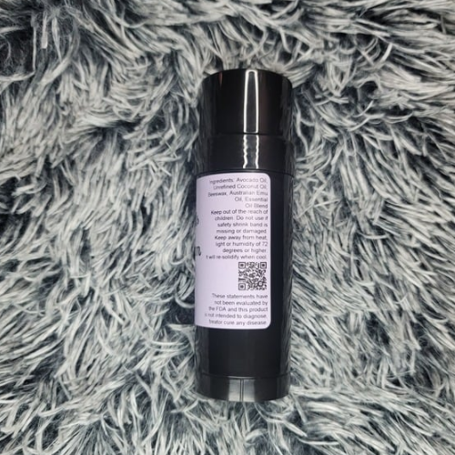 Black tube of Calm The Crazy product with label on a gray textured surface