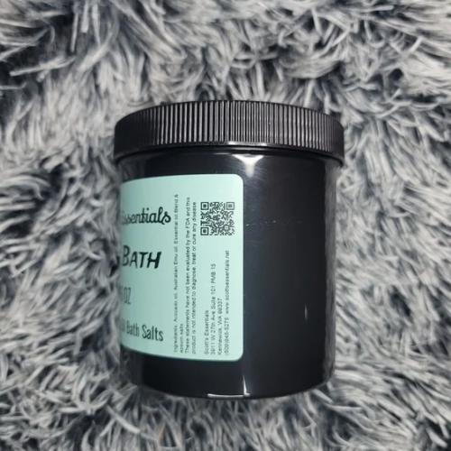 Black container of Ice Bath salts with a label on a gray textured surface