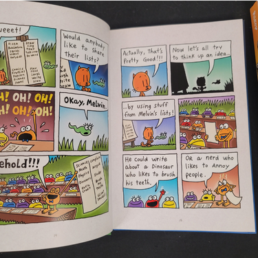Open book with colorful comic strip pages featuring cartoon characters Cat Kid and text.