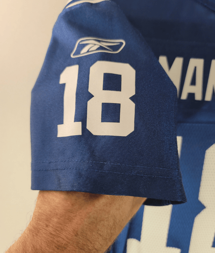 Blue sports jersey with number 18 on a beige background