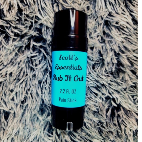 Bottle of 'Rub It Out' pain stick by Scott's Essentials on a textured surface